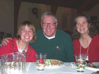 Three people in holiday attire at dinner